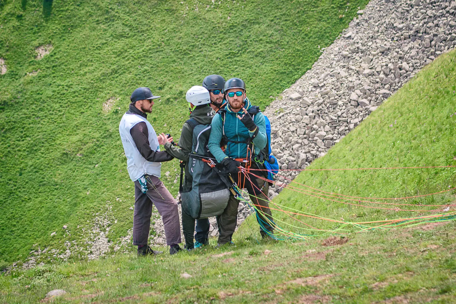 A tandem pilot briefing his passenger, both clipped in with the lines laid out