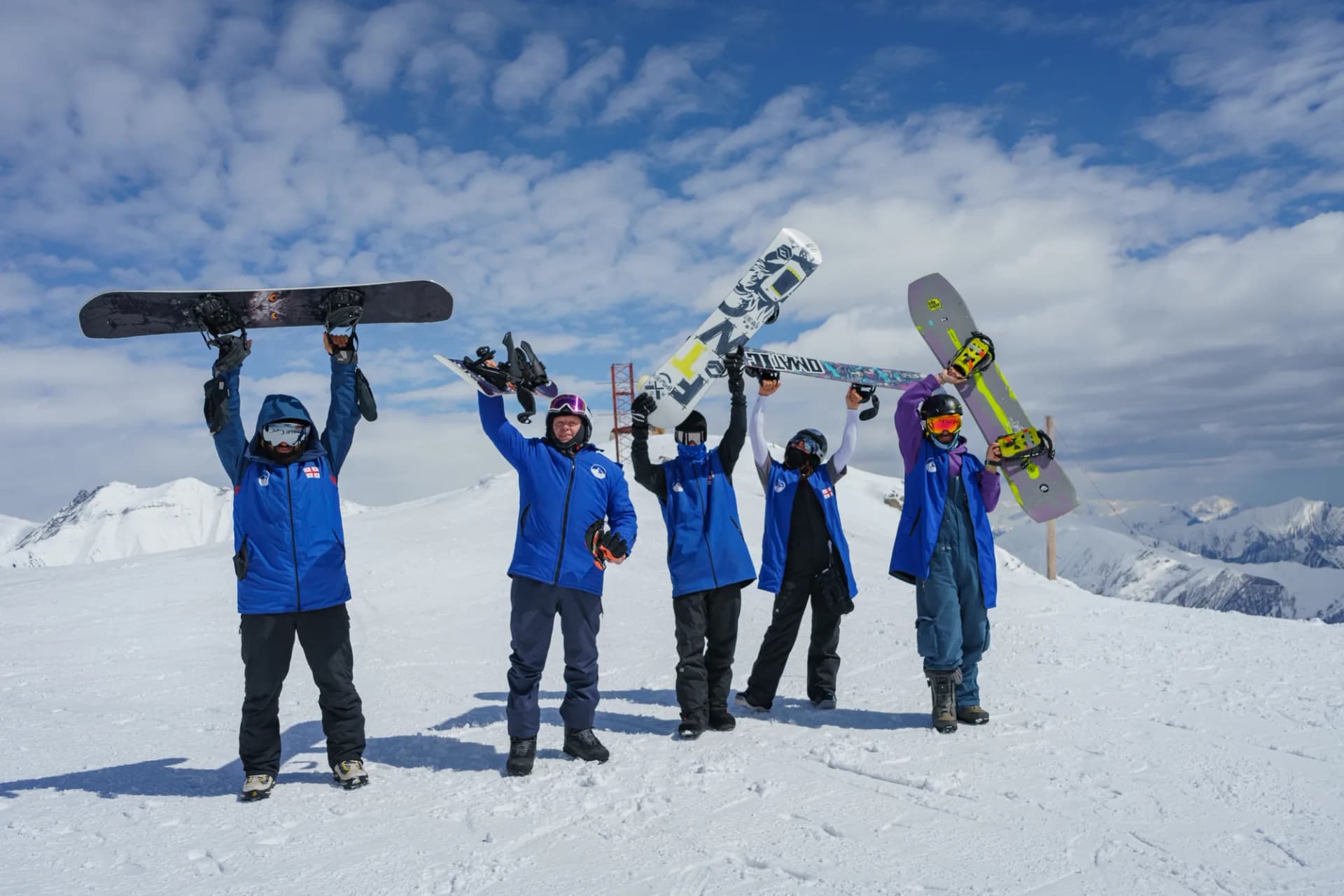 Gudauri 2000 instructors and students holding their boards up on the ridge above Gudauri